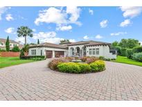 Stunning Mediterranean-style home with a circular driveway, mature landscaping, and a water fountain feature at 6233 Rydal Ct, Windermere, FL 34786
