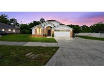 Charming single-Gathering home featuring a well-maintained lawn and attached two-car garage at 7243 Minippi Dr, Orlando, FL 32818