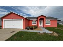 Charming single-Gathering home featuring a two-car garage and a well-maintained front yard landscape at 113 Kaigen Ct, Haines City, FL 33844
