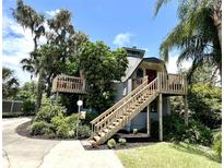 Unique home design with elevated wooden deck, lush landscaping, and mature trees at 1292 Nadine Dr, Deltona, FL 32738