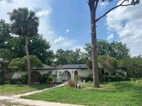 Charming single-story home with white stucco and lush landscaping at 219 Sheridan Ave, Longwood, FL 32750