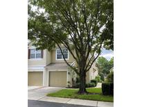 Charming townhome featuring a one-car garage, mature trees, and a well-manicured front yard at 2548 Galliano Cir, Winter Park, FL 32792