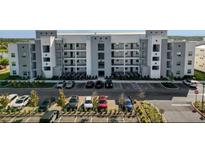 Modern apartment complex featuring a parking lot and well maintained landscaping at 3191 Paradox Cir # 102, Kissimmee, FL 34746