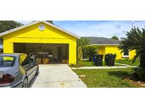 Bright yellow house with an open garage, set on a sunny day in a community at 4719 Miranda Cir, Orlando, FL 32818