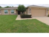 Charming home featuring a well-maintained lawn and a two-car garage with stone-accented columns at 4852 Magnolia Preserve Dr, Winter Haven, FL 33880