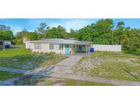 Charming single-story home featuring a covered carport, complemented by a well-maintained lawn and inviting turquoise front door at 624 Cardinal St, Ocoee, FL 34761