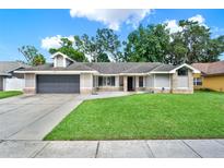 Charming single-story home with a well-manicured lawn and a two-car garage at 679 N Endeavour Dr, Winter Springs, FL 32708