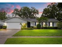 Charming single-story home with a well-maintained lawn and tidy landscaping, completed with a two car garage at 7011 Archwood Dr, Orlando, FL 32819