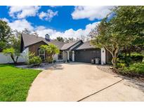 Charming single-Gathering home featuring a well-manicured lawn, mature trees, and a spacious driveway at 1000 Chesterfield Cir, Winter Springs, FL 32708
