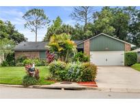 Charming single-story home with brick accents, lush landscaping, and an attached two-car garage at 126 Duncan Trl, Longwood, FL 32779