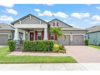 Charming two-story home with a well-manicured lawn, beautiful landscaping, and a cozy front porch at 13227 Spring Grove Way, Winter Garden, FL 34787