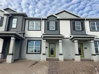 Charming townhouse featuring modern architectural details and a welcoming entrance with green door and dark shutters at 1356 Lumpini St, St Cloud, FL 34771