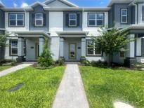 Charming townhouse with well-manicured lawn, inviting walkway, and covered entry, creating a welcoming curb appeal at 1411 Mount Royal Dr, St Cloud, FL 34771