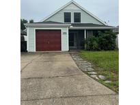 Charming single-Gathering home featuring a red garage door, front porch, and well-maintained lawn at 1413 Brookebridge Dr, Orlando, FL 32825