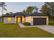 Charming single-story home with a well-maintained lawn, neutral stucco, and an attached two-car garage at 14930 Sw 66Th Ave Rd, Ocala, FL 34473