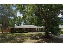 Charming one-story home featuring a well-maintained lawn and mature trees providing shade at 1511 Hobson St, Longwood, FL 32750