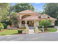 Charming two-story home featuring a red tile roof, meticulously landscaped yard, and inviting fountain feature at 1542 Islay Ct, Apopka, FL 32712