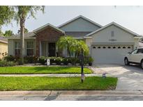 Charming single-story home featuring a stone facade, well-manicured lawn, and attached two-car garage at 2237 Osprey Woods Cir, Orlando, FL 32820