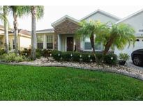Charming single-story home with stone accents, lush landscaping, and a well-manicured lawn at 2237 Osprey Woods Cir, Orlando, FL 32820