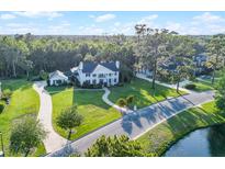 Stunning white mansion with manicured lawn, lush trees, and winding driveway creates an inviting estate at 2487 River Tree Cir, Sanford, FL 32771