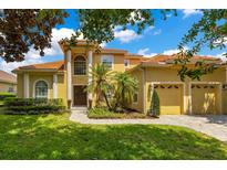 Stunning two-story home with a vibrant yellow facade, manicured lawn, and well-maintained landscaping at 283 Lakay Pl, Longwood, FL 32779
