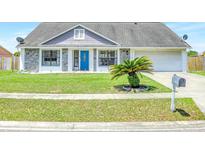 Charming single-story home featuring a well-manicured lawn and a bright blue front door at 3038 Golden Rock Dr, Orlando, FL 32818
