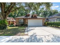 Charming brick home featuring a two-car garage, manicured lawn, and a welcoming front entrance at 316 Dornoch Ct, Winter Springs, FL 32708