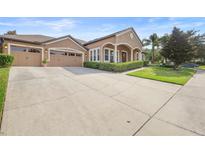 Charming home boasts a well-manicured lawn and a spacious driveway leading to a three-car garage at 3551 Statham Dr, Apopka, FL 32712