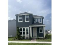 Charming two-story home features a gray exterior, white trim, well-manicured lawn, and neatly landscaped front yard at 446 Scotsmans Pl, Debary, FL 32713