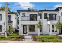 Modern two-story home with a white exterior, black trim, and a small balcony at 523 W Princeton St # 1, Orlando, FL 32804