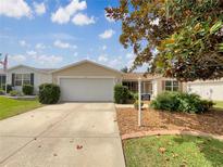 Charming single-story home featuring a well-maintained front yard and a two-car garage at 9514 Se 168Th Maplesong Ln, The Villages, FL 32162