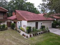 Charming single-story home featuring a red tile roof and a well-manicured front yard with lush landscaping at 1053 W Pebble Beach Cir, Winter Springs, FL 32708