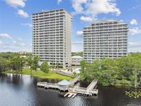 Stunning view of two tall condo buildings with a pier extending into the lake, showcasing a serene waterfront living at 13427 Blue Heron Beach Dr # 404, Orlando, FL 32821