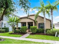 Charming single-story home with a well-manicured lawn, lush landscaping, and inviting front porch at 15647 Braintree Ln, Winter Garden, FL 34787