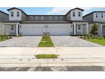 Modern townhome exterior featuring individual driveways and two-car garages at 1797 Archer Dr, Minneola, FL 34715