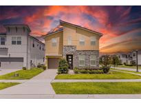 Beautiful two-story home featuring stone accents, well-manicured landscaping, and a brick-paved driveway at 1809 Tropical Palms Cir, Kissimmee, FL 34747