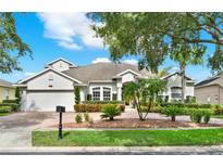 Beautiful single-Gathering home featuring a brick driveway, lush landscaping, and a well-maintained lawn at 1932 Reed Hill Dr, Windermere, FL 34786
