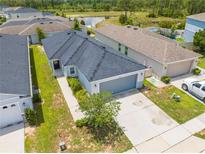 Charming single-Gathering home showcasing a well-maintained lawn, two-car garage, and a serene neighborhood pond view at 236 Miles Ct, Davenport, FL 33837