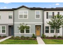 Charming townhome with a welcoming yellow front door and fresh, modern landscaping at 3256 Merton Aly, Orlando, FL 32808