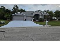 Charming home featuring a three-car garage, well-manicured lawn, and tasteful landscaping at 4351 Winding Oaks Cir, Mulberry, FL 33860
