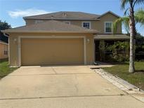Inviting two-story home featuring an attached two-car garage and a well-manicured lawn at 436 Hammerstone Ave, Haines City, FL 33844