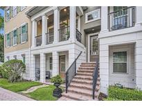 Inviting townhome exterior with brick steps, black railings, and covered porch, perfect for enjoying the outdoors at 524 Lanark Ct, Orlando, FL 32806