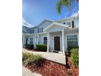 Inviting townhome featuring blue siding, shuttered windows, and a covered entryway at 5370 Diplomat Ct # 107, Kissimmee, FL 34746
