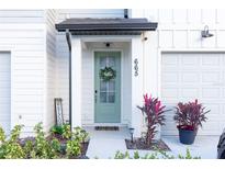 Inviting front entrance with a light green door and a welcoming wreath at 665 Longboat Dr, Davenport, FL 33896