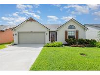 Charming single-story home featuring a two-car garage and lush, well-manicured front lawn at 685 Middlebury Loop, New Smyrna Beach, FL 32168