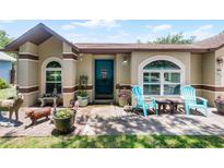Charming home featuring a cozy front porch with blue chairs and decorative accents at 891 Licaria Dr, Ocoee, FL 34761
