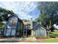 Attractive condo building with large windows, stairs to the entrance and landscaping at 947 Bird Bay Ct # 205, Lake Mary, FL 32746