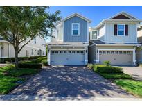 Charming townhome with a two-car garage and brick paved driveway, complemented by lush landscaping at 978 E 10Th St, Apopka, FL 32703