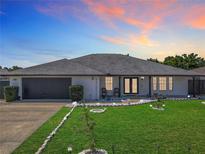 Charming home with manicured lawn, rock border, modern exterior lighting and walkway to front door at 1129 Madura Dr, Deltona, FL 32725