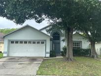 Charming single-story home featuring a two-car garage, arched window, and mature landscaping at 11606 Goodwyck Dr, Orlando, FL 32837